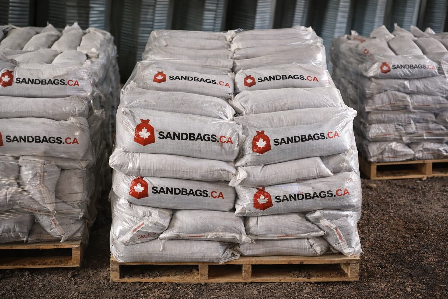 Pallets of wrapped SandBags.ca sandbags in a warehouse
